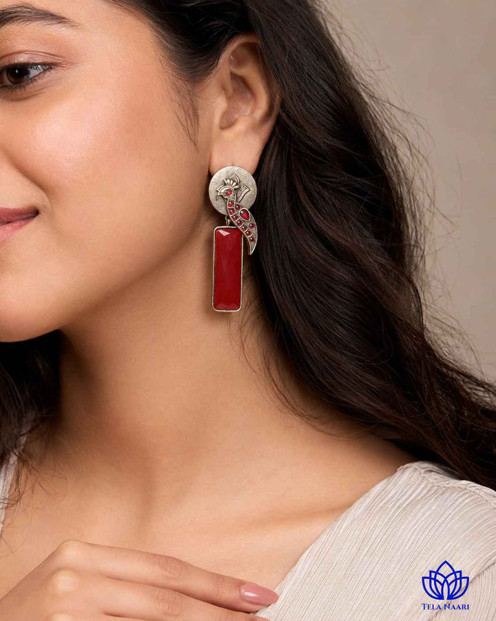 Versatile design pairs a silver-plated finish with red stones.