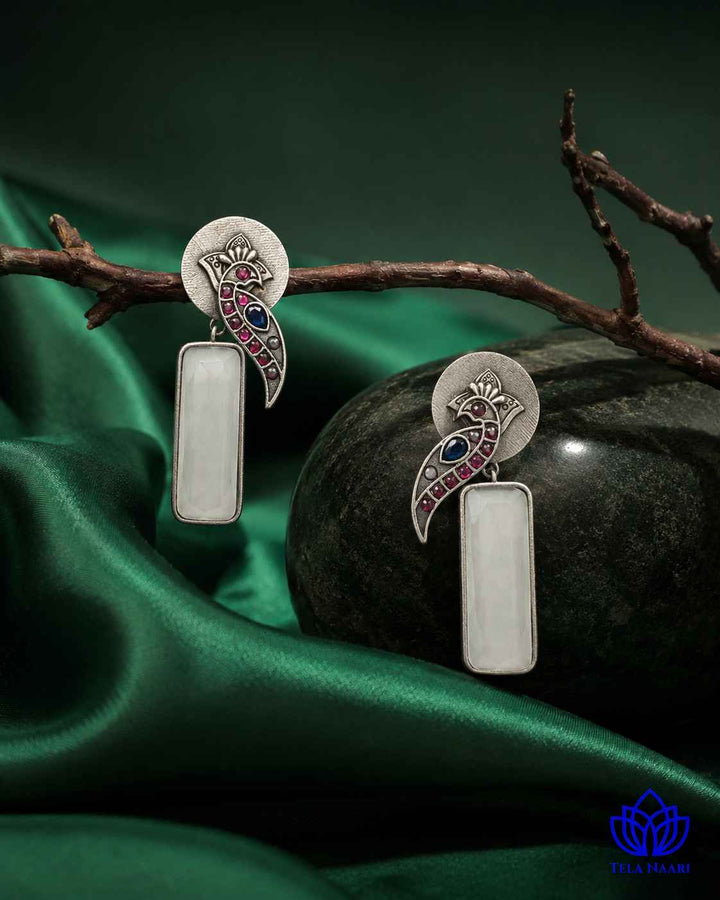 Delicate stone work highlights the intricate design of this earring.