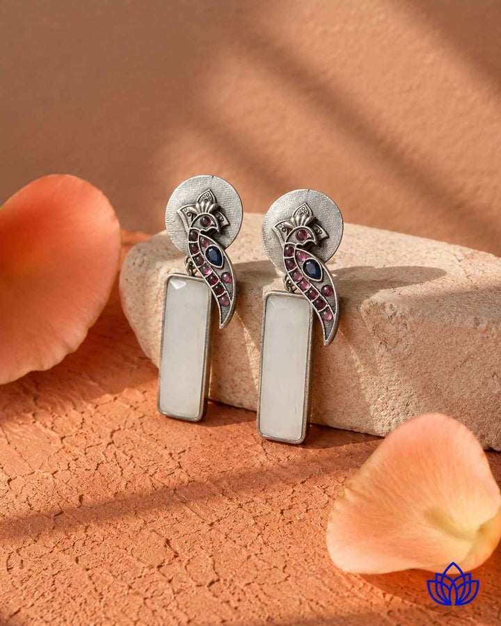 Silver-plated finish covers the surface of this white earring.