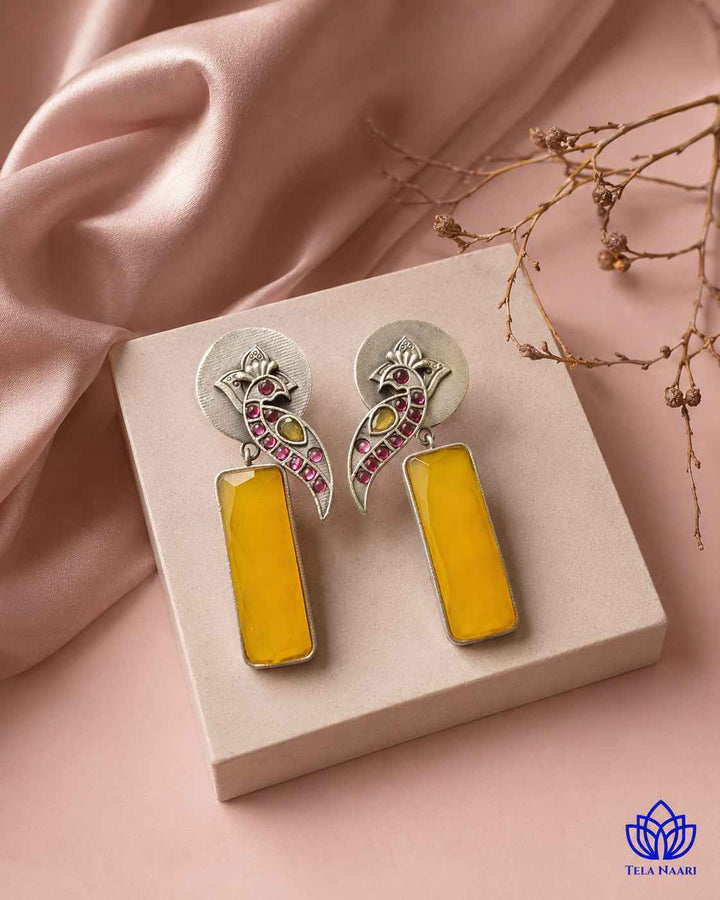 Brass construction supports the handmade design of this earring.