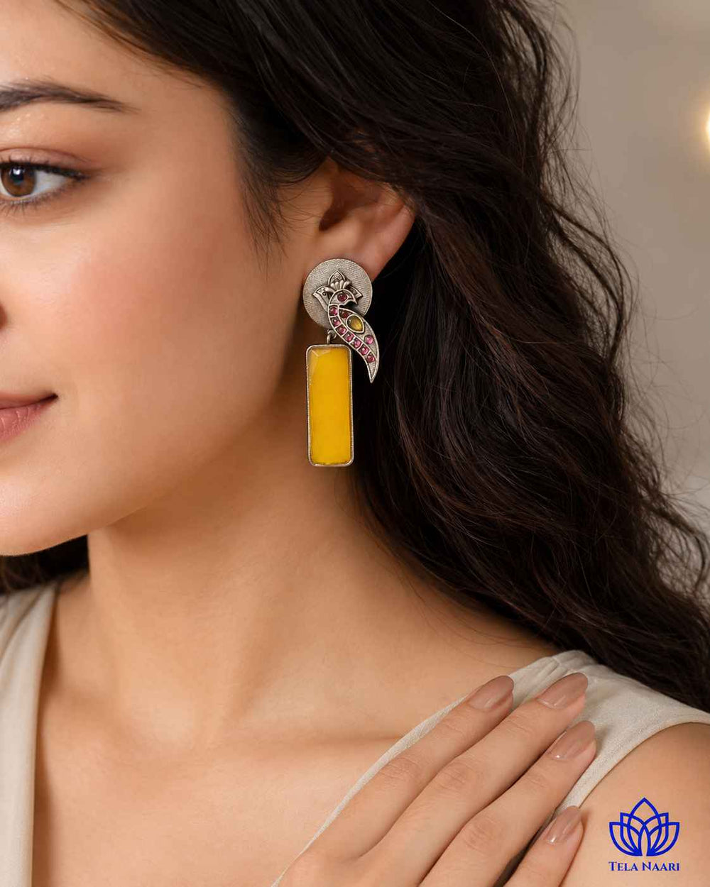 Silver-plated finish covers the surface of this yellow earring.
