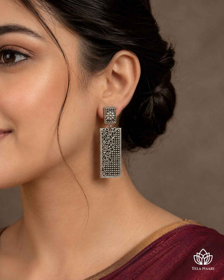Smooth silver-plated surface highlights the graceful teardrop shape of this brass earring.
