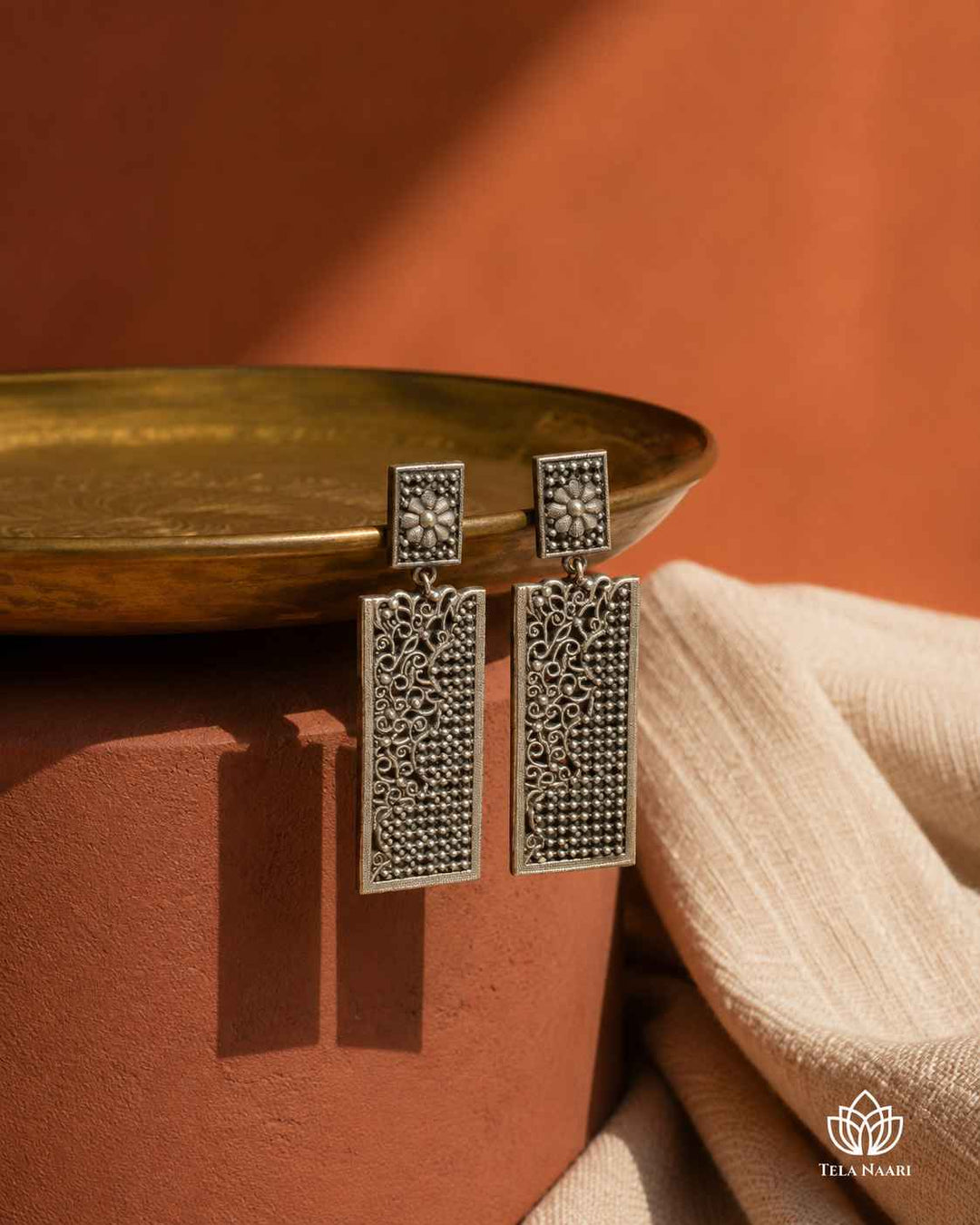 Graceful teardrop curve defines the silhouette of this silver-plated brass earring.