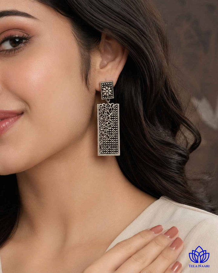Delicate dangler design by Tela Naari features a silver-plated teardrop silhouette in brass.