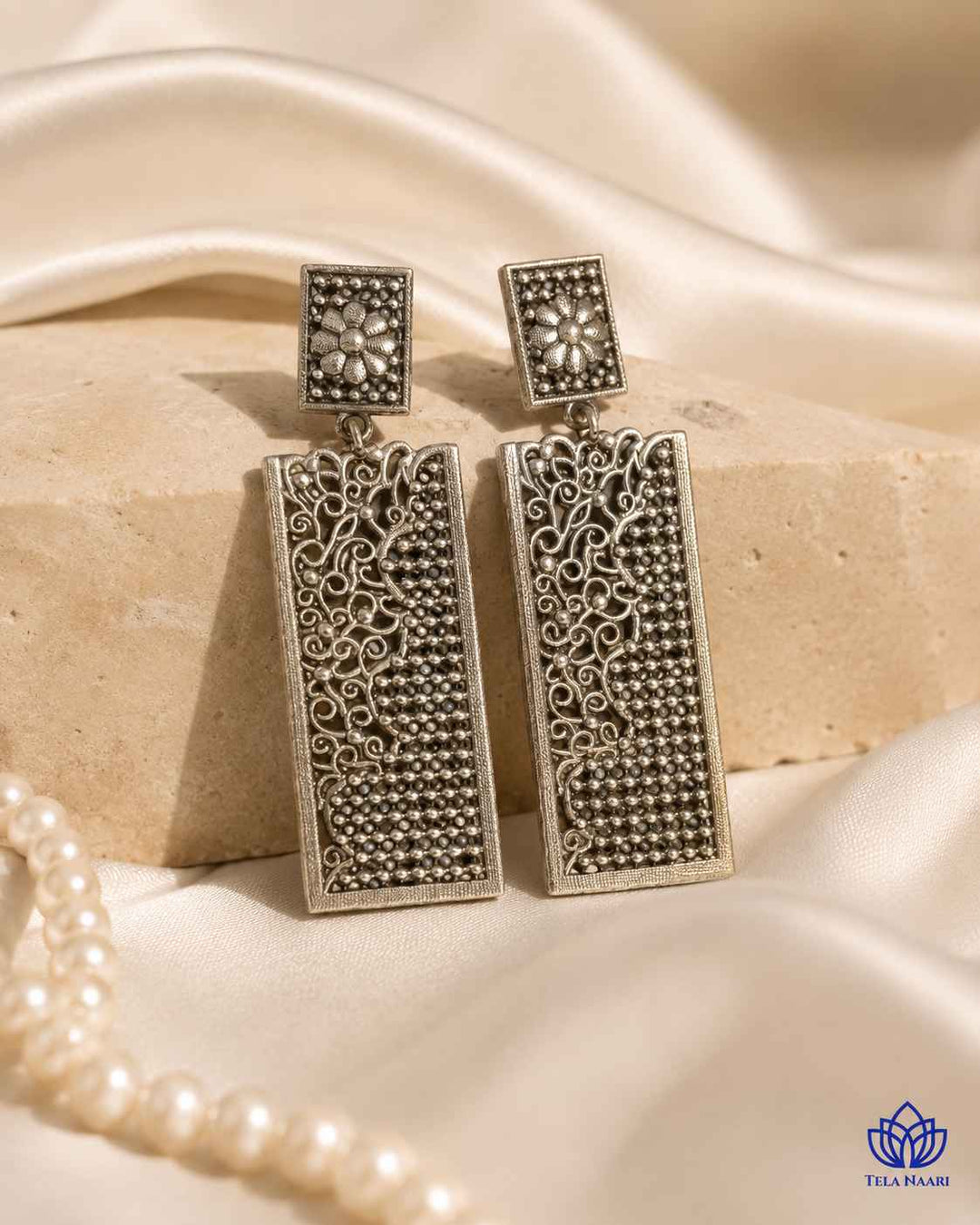 Teardrop silhouette earrings crafted in silver-plated brass with a smooth finish.