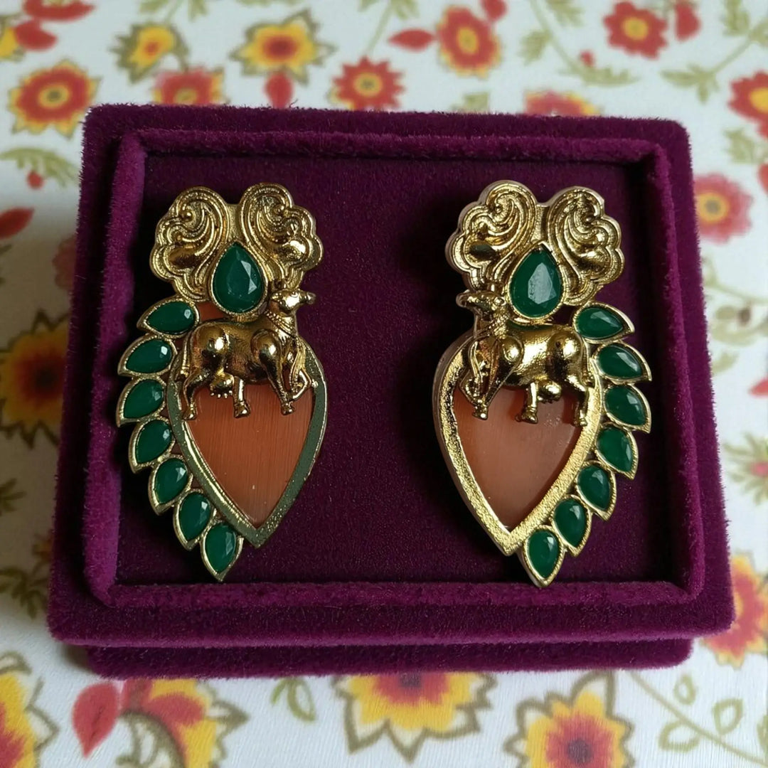 Delicate stud earring features brass construction with stone detailing.