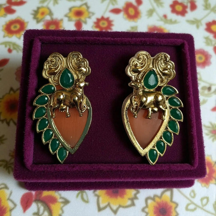 Delicate stud earring features brass construction with stone detailing.