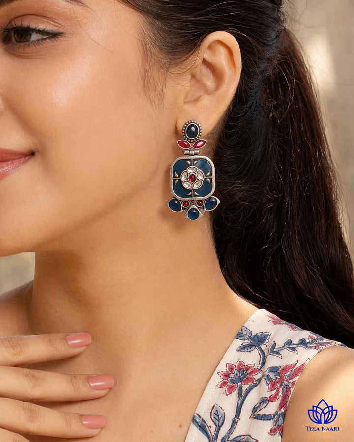 Blue dangler silhouette defines the shape of this earring.