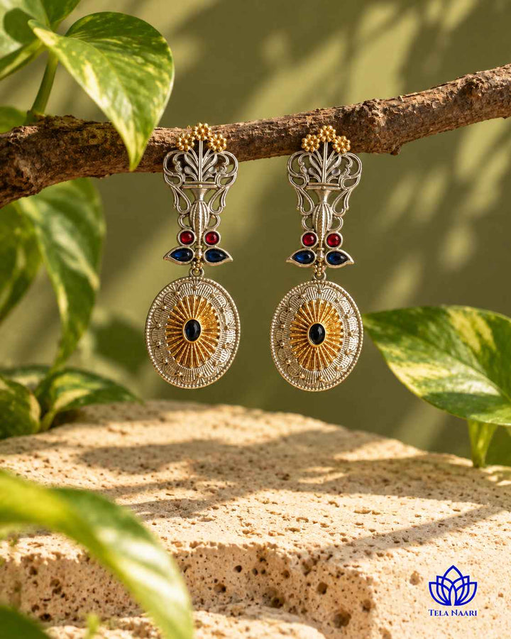 Brass construction supports the peacock design of this earring.