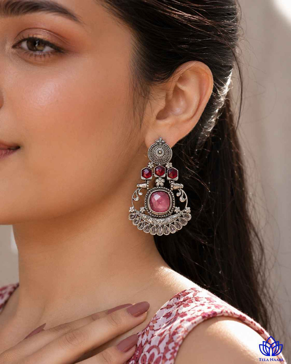 Glass bead accents highlight the vibrant pink tones of this earring.