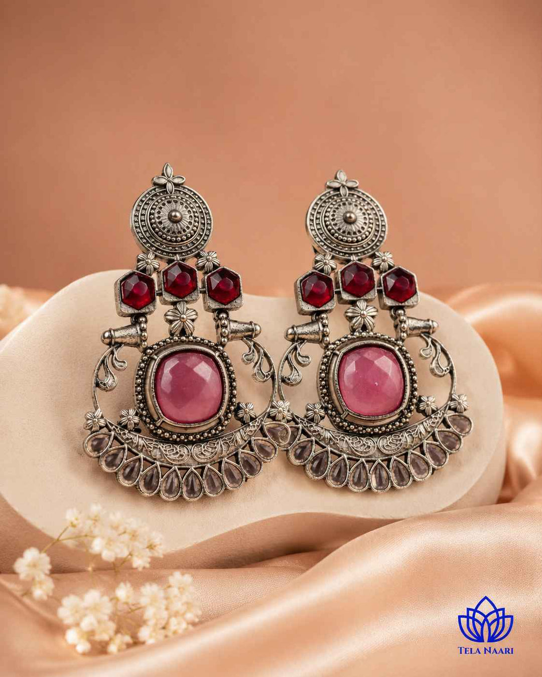 Pink stone detailing sits at the centre of this silver-plated earring.