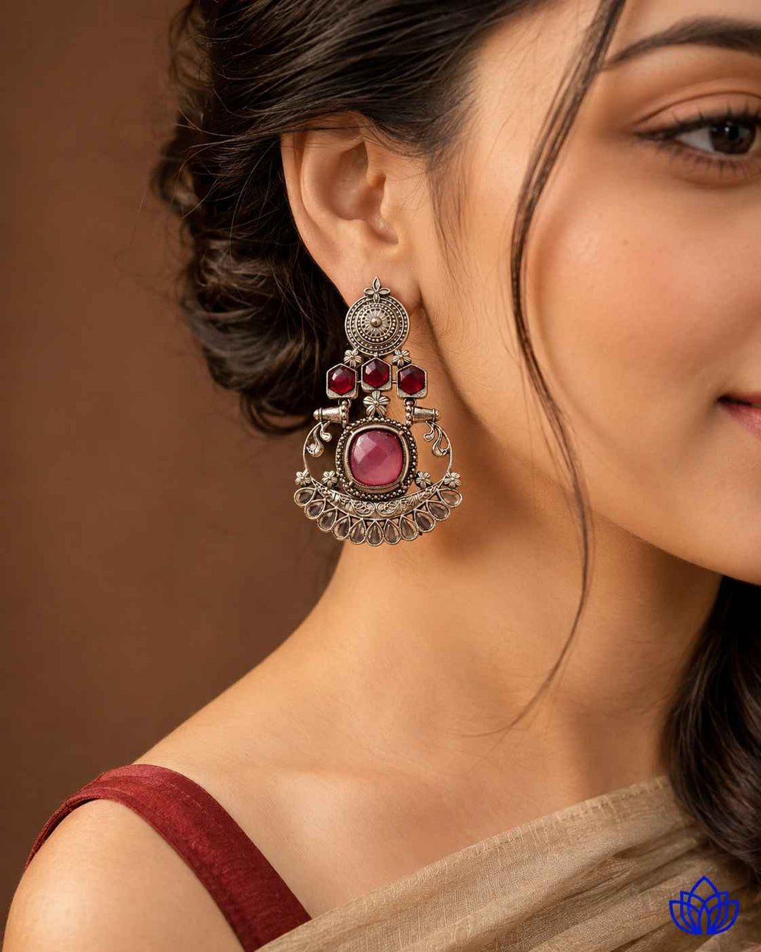 Statement silhouette pairs pink stone detailing with silver plating.