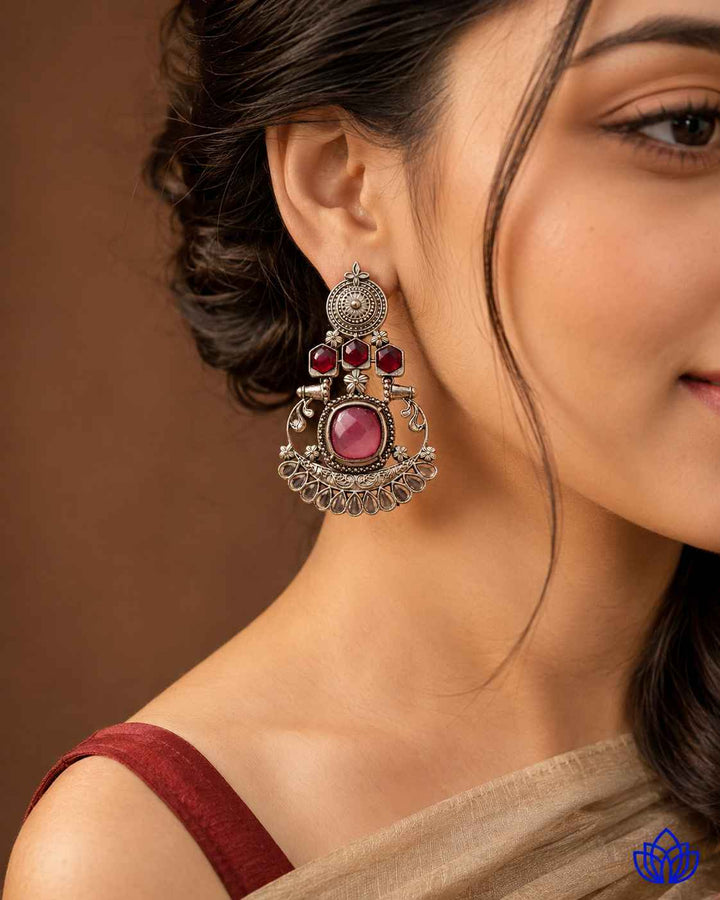 Statement silhouette pairs pink stone detailing with silver plating.