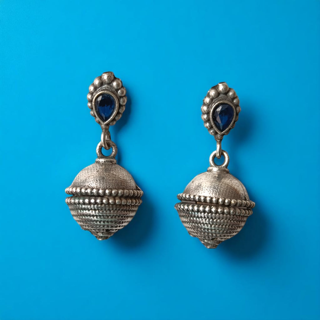 Delicate bell motif hangs from this oxidised silver dangler earring.