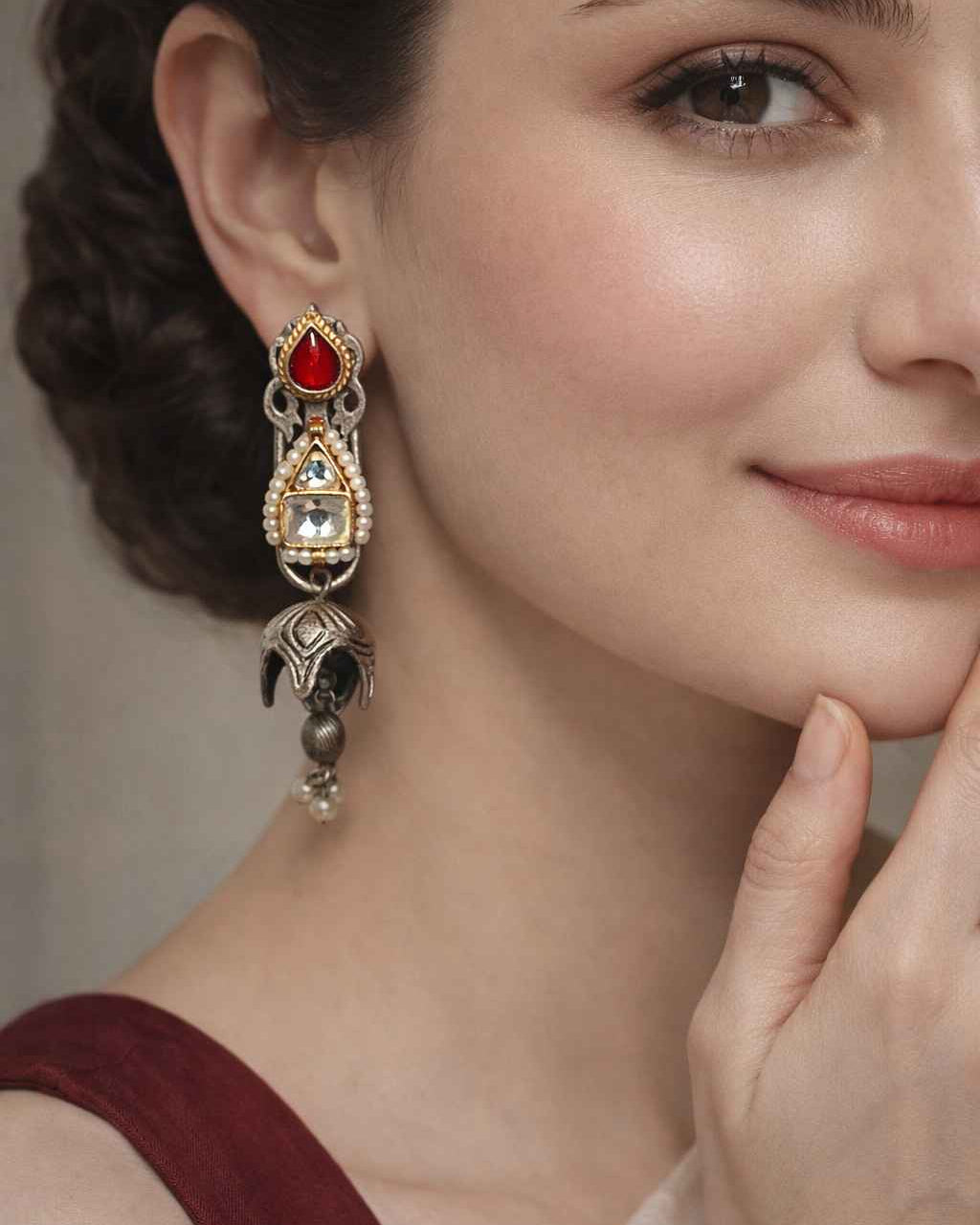 Intricate kundan work shapes the silhouette of this dual-tone earring.
