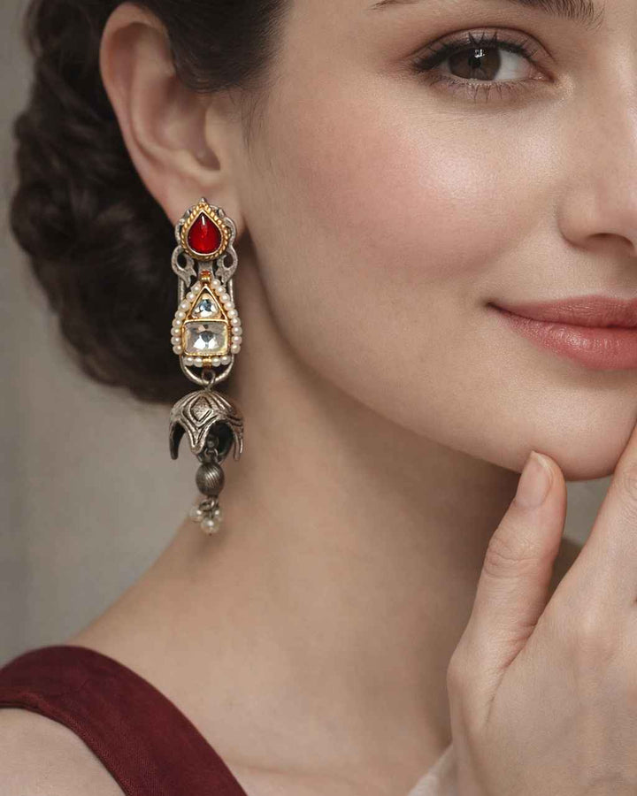 Intricate kundan work shapes the silhouette of this dual-tone earring.
