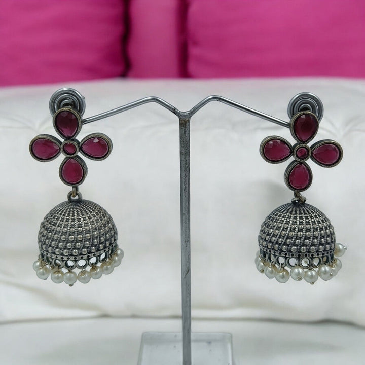 Yogita oxidised silver jhumki earrings in red — bold for party wear, reception functions, and traditional attire.
