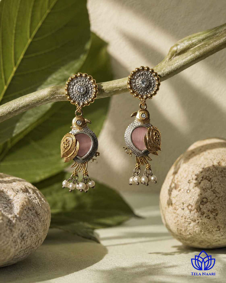 Brass construction supports the nature-inspired bird design of this earring.