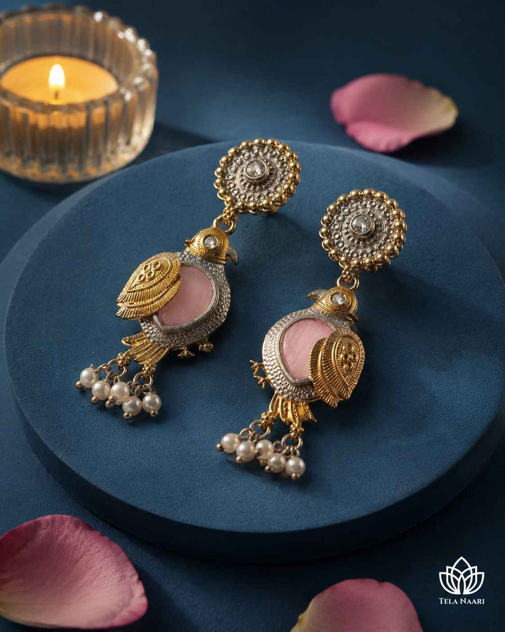 Nature-inspired charm defines the silhouette of this pink earring.