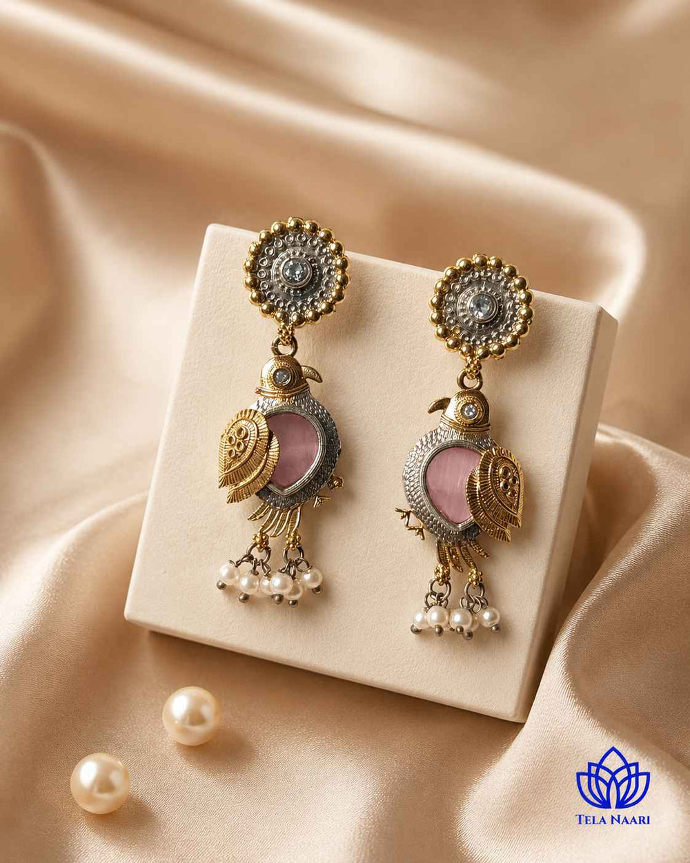 Pearl drop accents hang from this bird-motif earring.