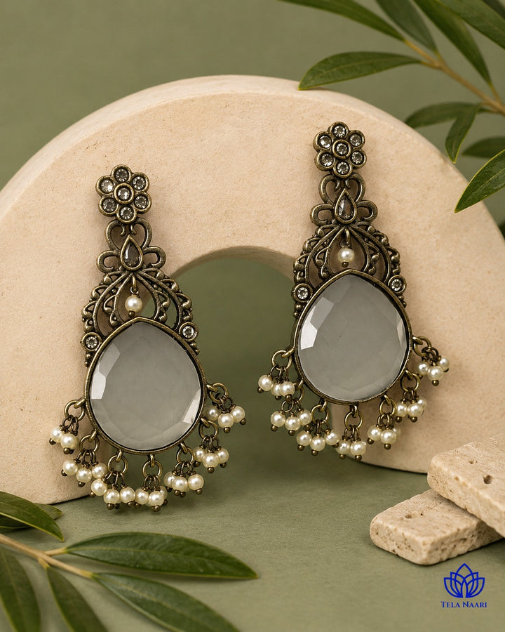 Brass construction supports the layered stone design of this earring.