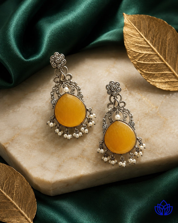 Brass construction supports the stone detailing of this earring.