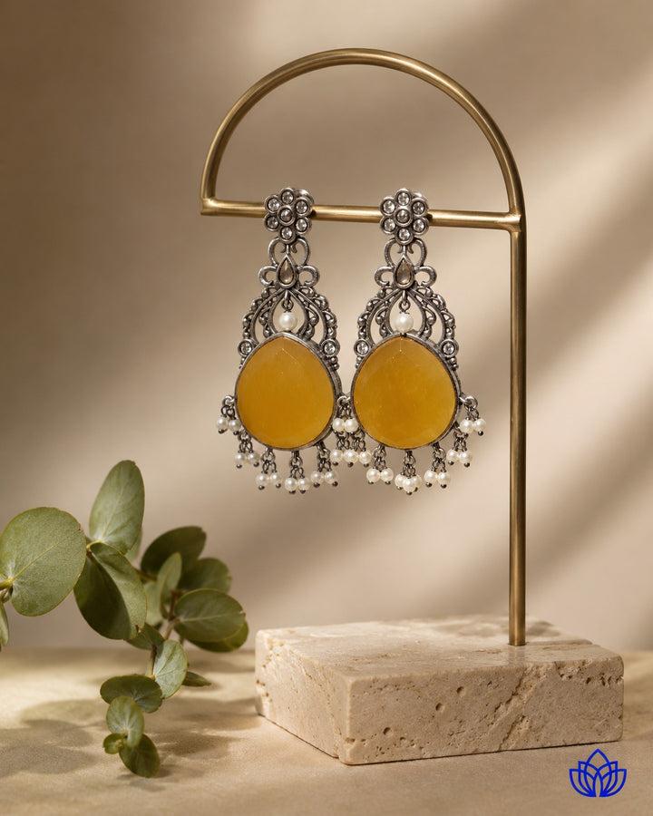Festive yellow tones brighten the silver-plated surface of this earring.