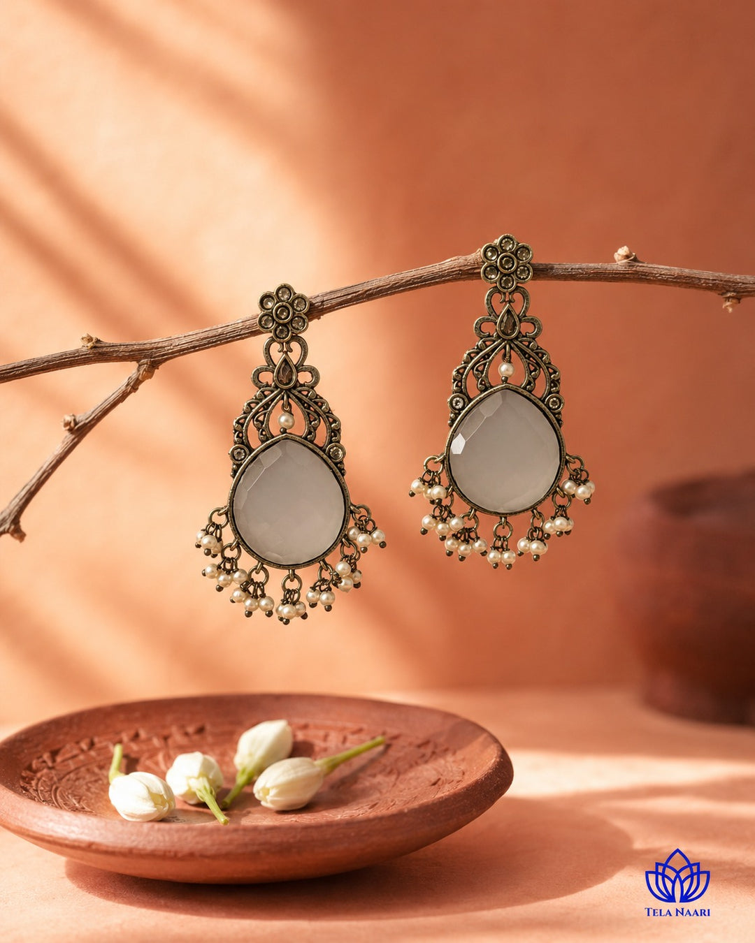 Glass bead detailing decorates the surface of this white earring.