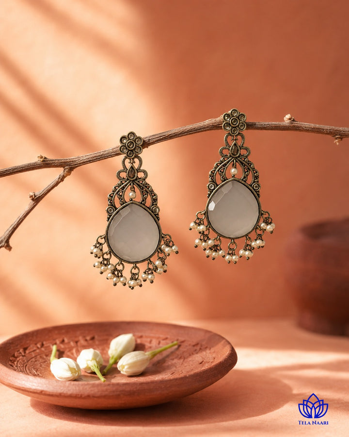 Glass bead detailing decorates the surface of this white earring.