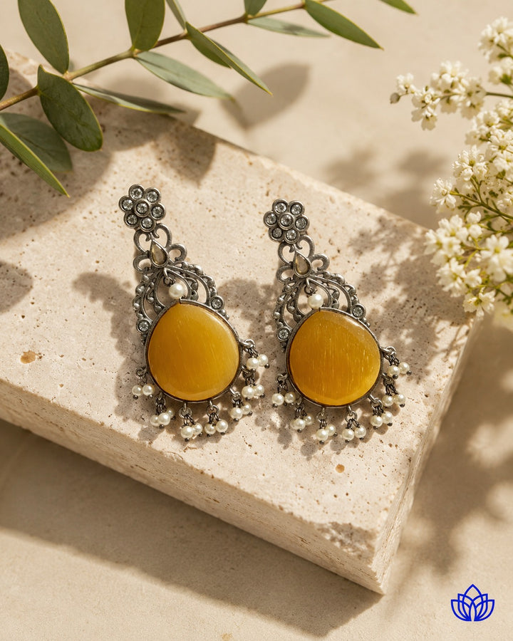 Glass bead detailing decorates the surface of this yellow earring.