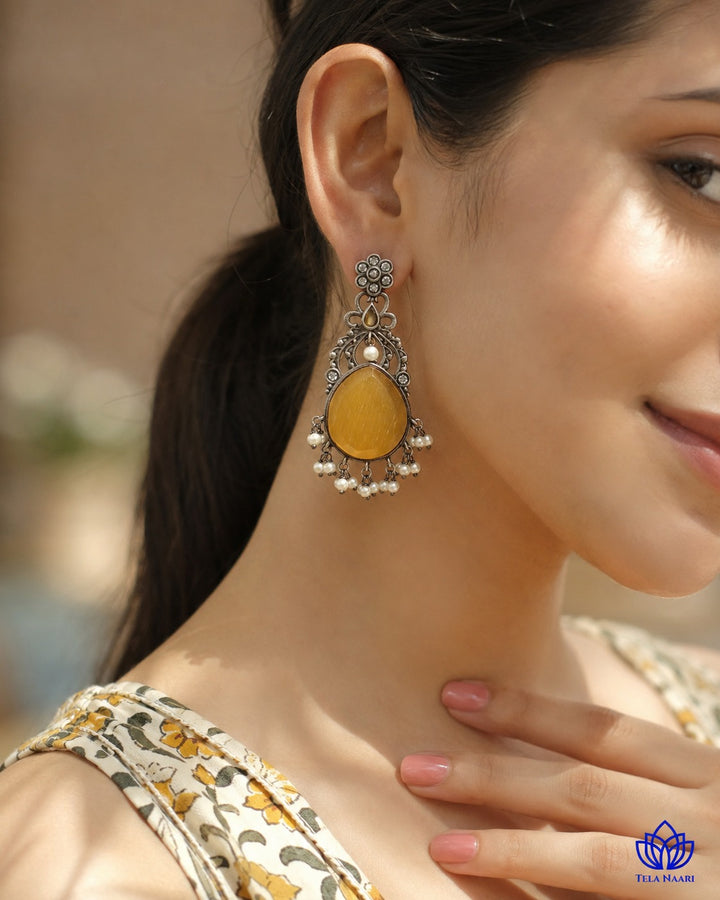Post and back closure secures this silver-plated yellow earring.