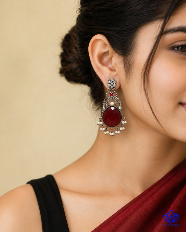 Red stone detailing sits at the centre of this silver-plated earring.