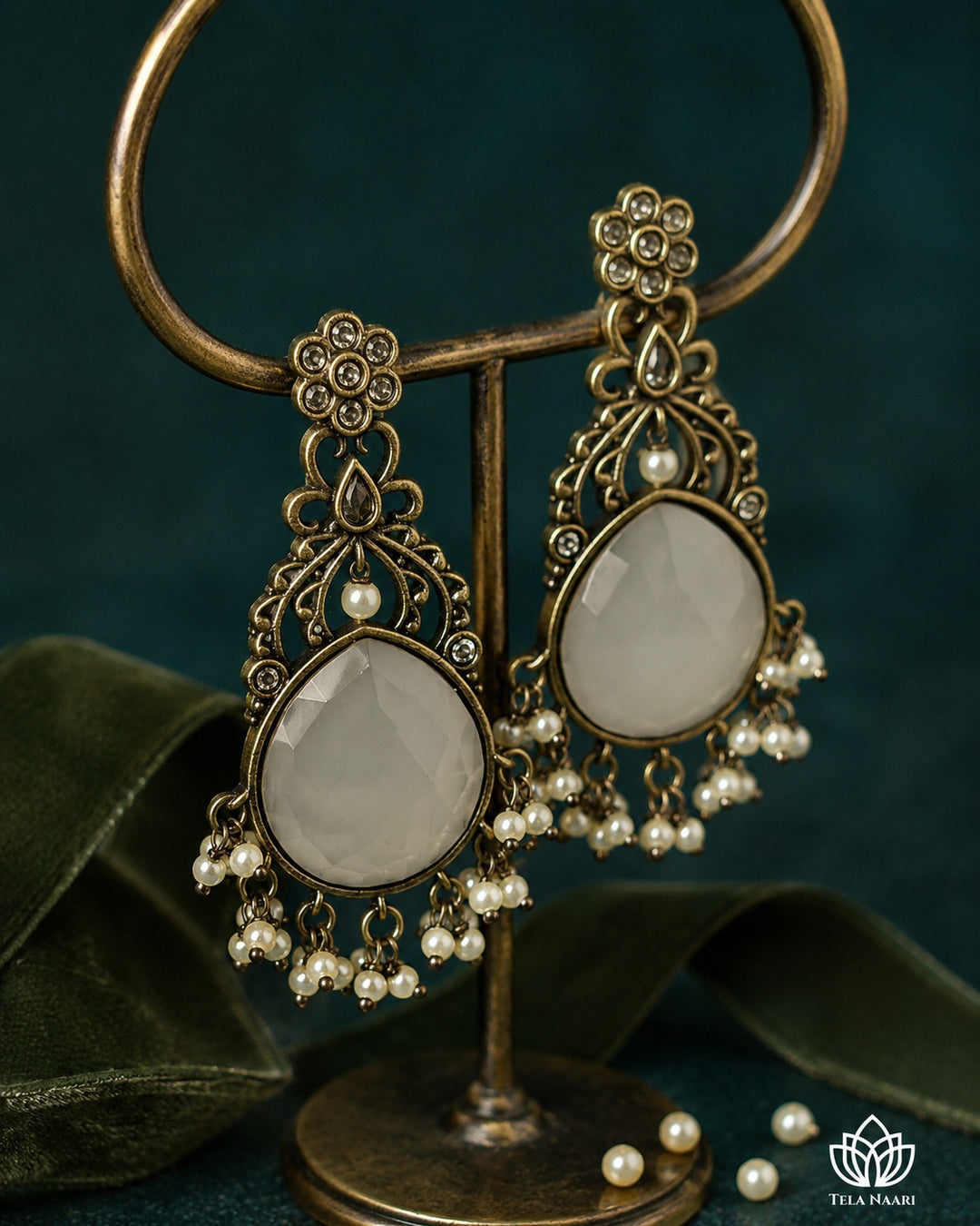 Soft white tones brighten the stone detailing of this earring.