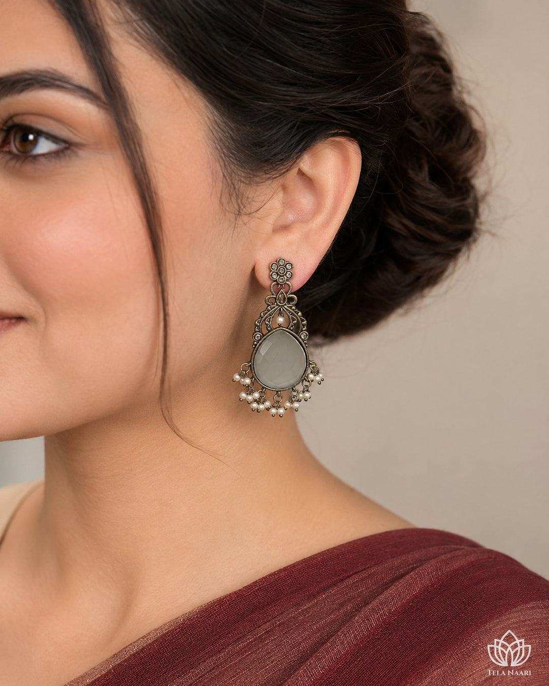 Ornate stone detailing decorates the surface of this white earring.