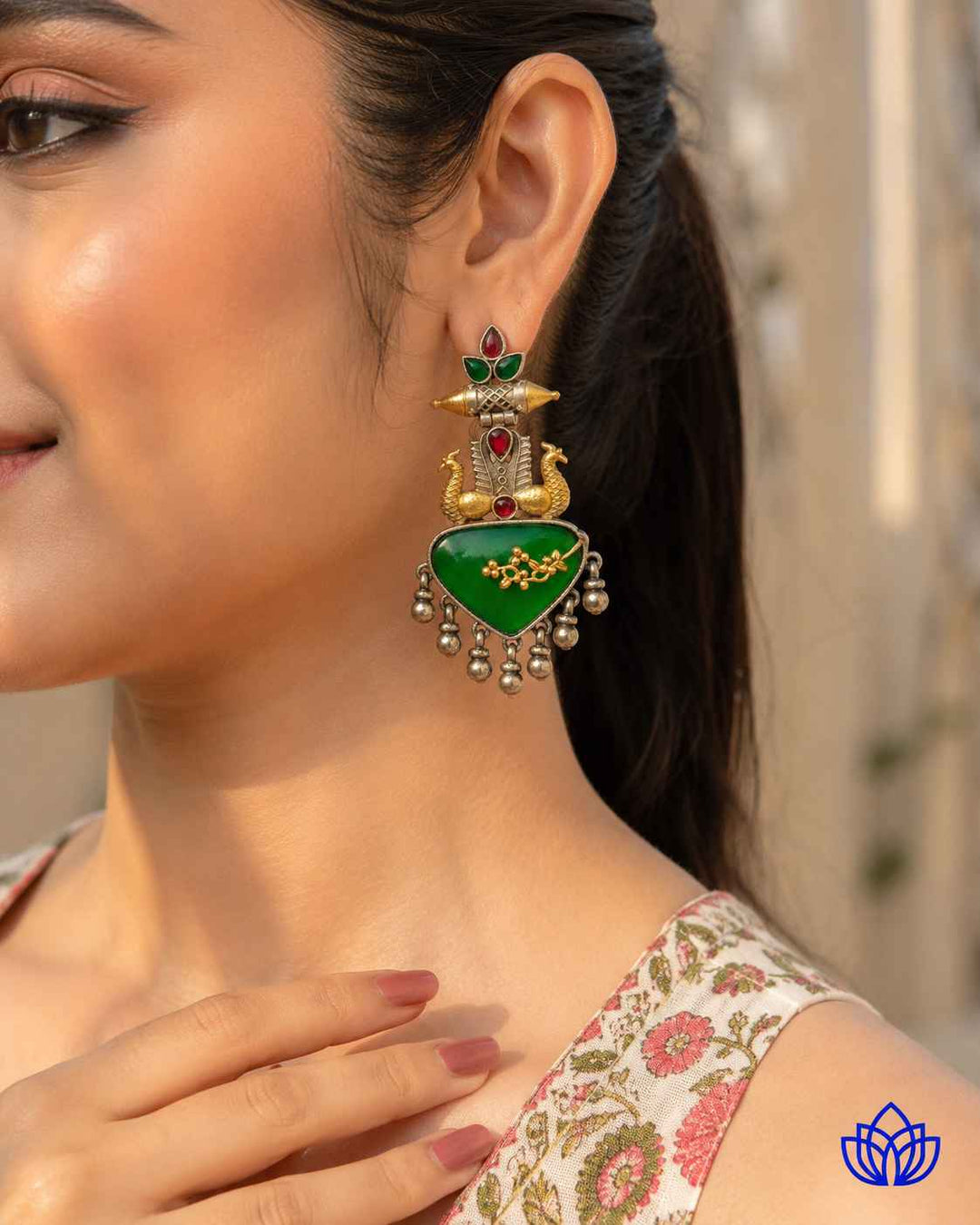 Metallic contrast defines the two-tone finish of this green earring.