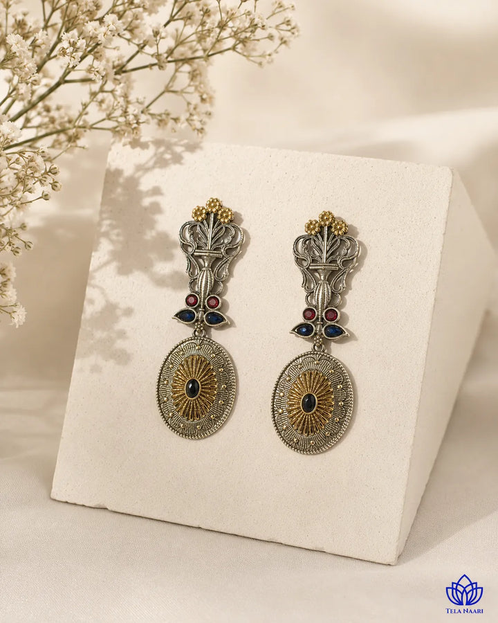 Brass construction supports the peacock silhouette of this earring.