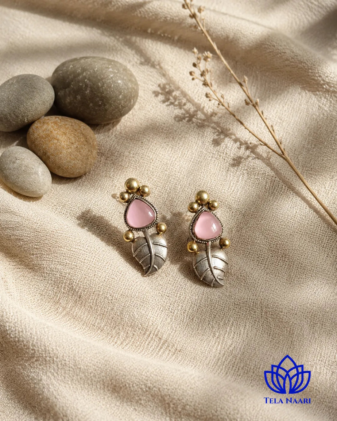 Pink stone accents sit at the centre of this leaf stud.