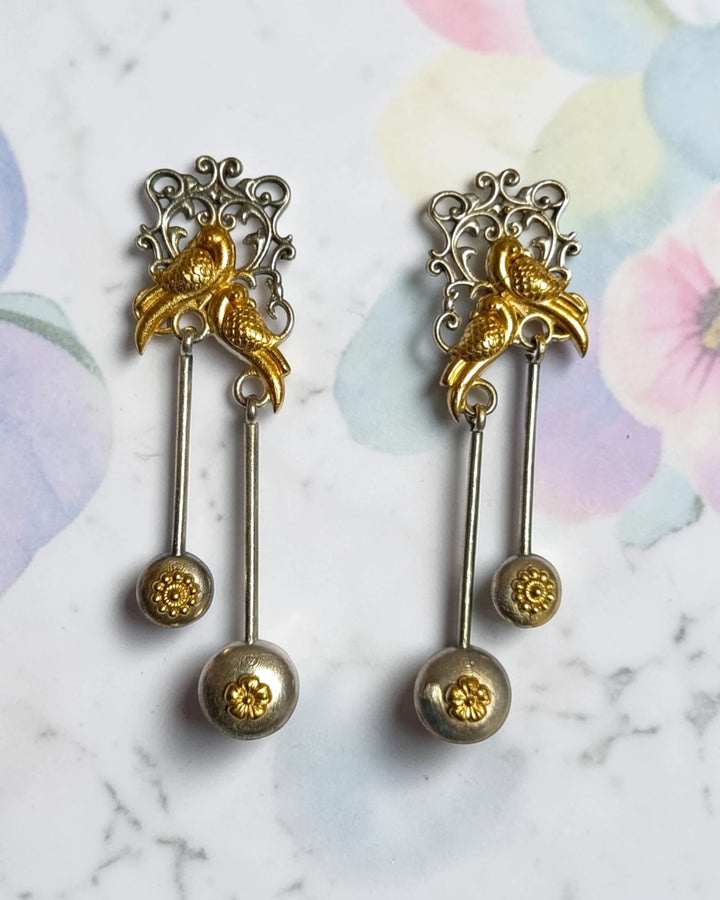 Dual-tone gold finish covers the intricate bird motif of this earring.