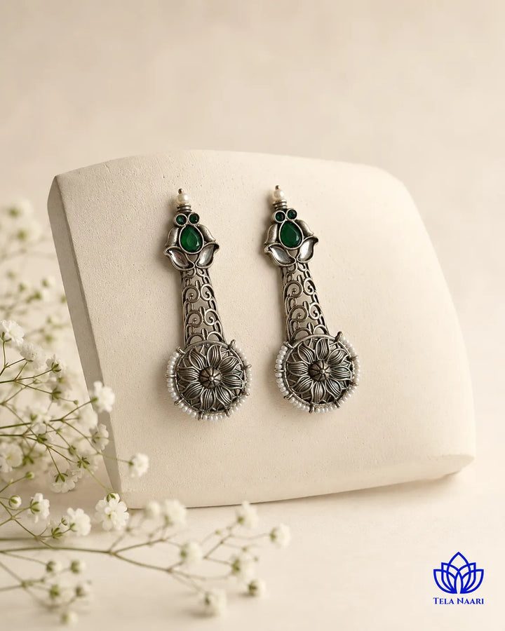 Luminous emerald pearl detailing shapes the silhouette of this earring.