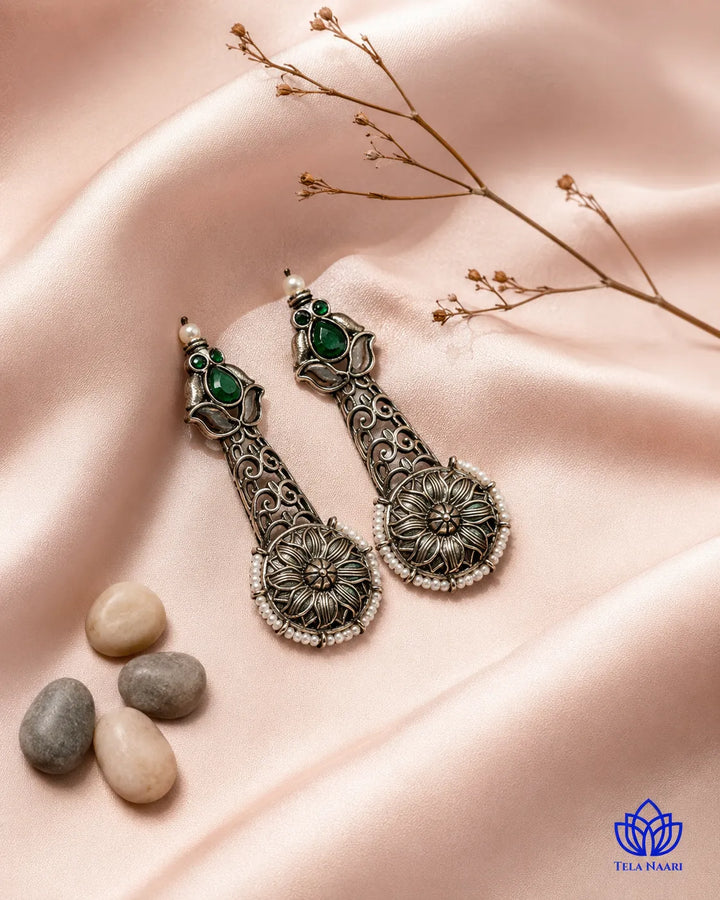 Sophisticated silhouette pairs emerald pearls with oxidised silver.