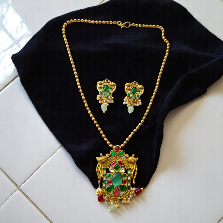 Adjustable hook clasp secures this emerald pendant necklace set.