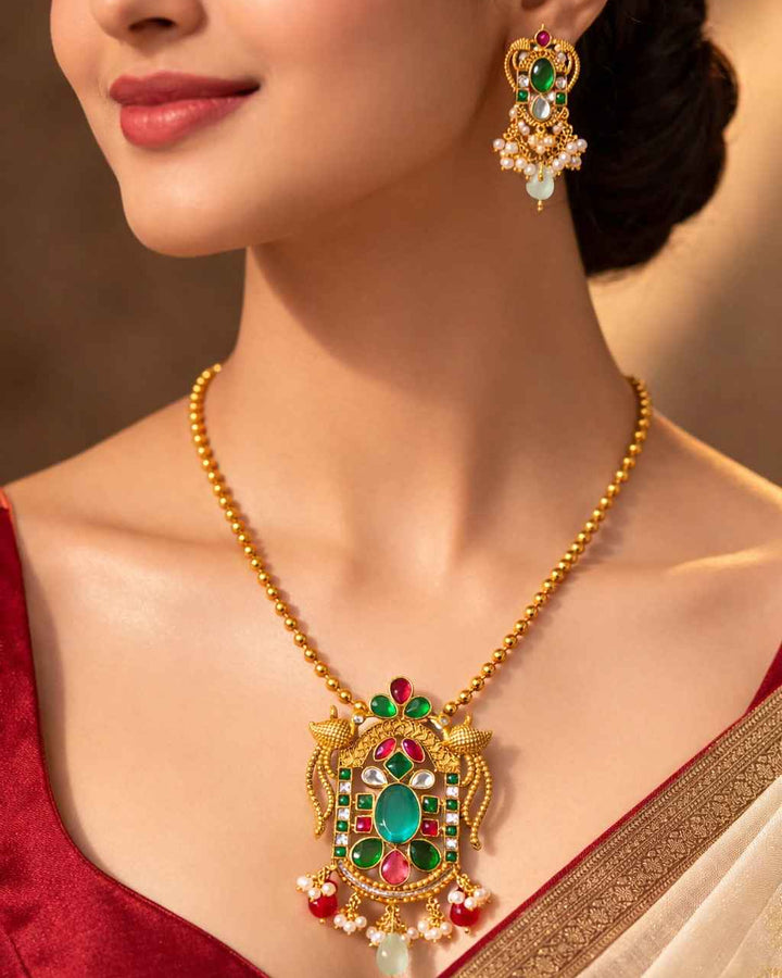 Luxurious emerald green stones shape the centrepiece of this pendant.