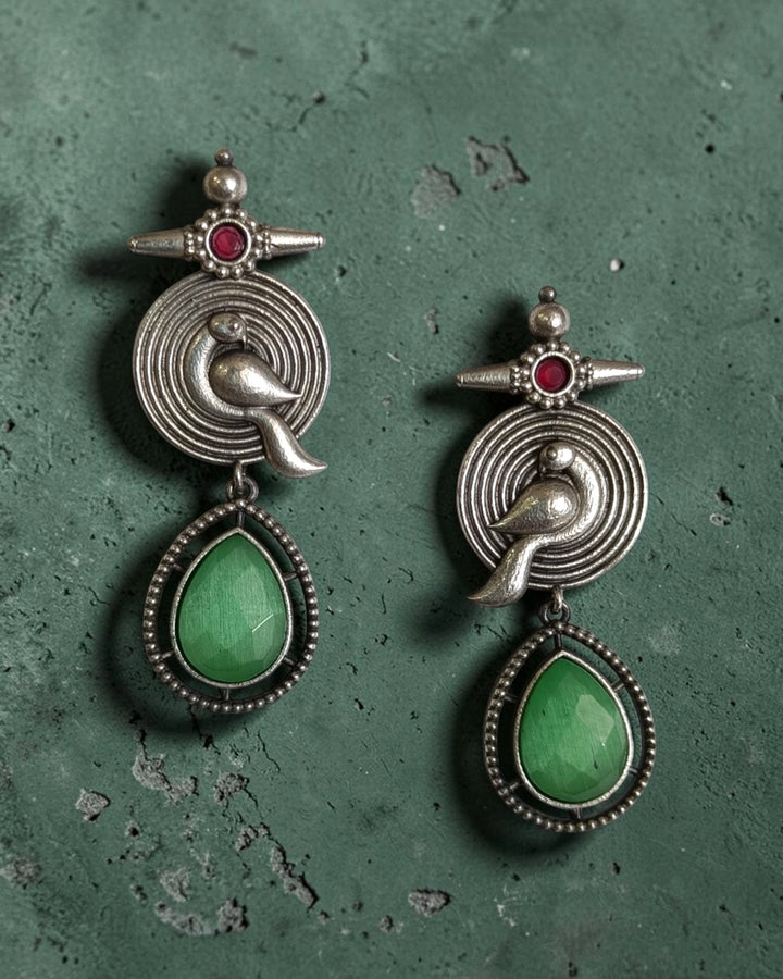 Teardrop-shaped green stone completes the tribal design of this earring.