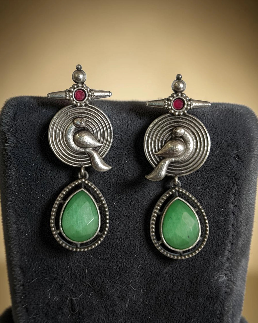 Red enamel accent highlights the oxidised bird design of this earring.