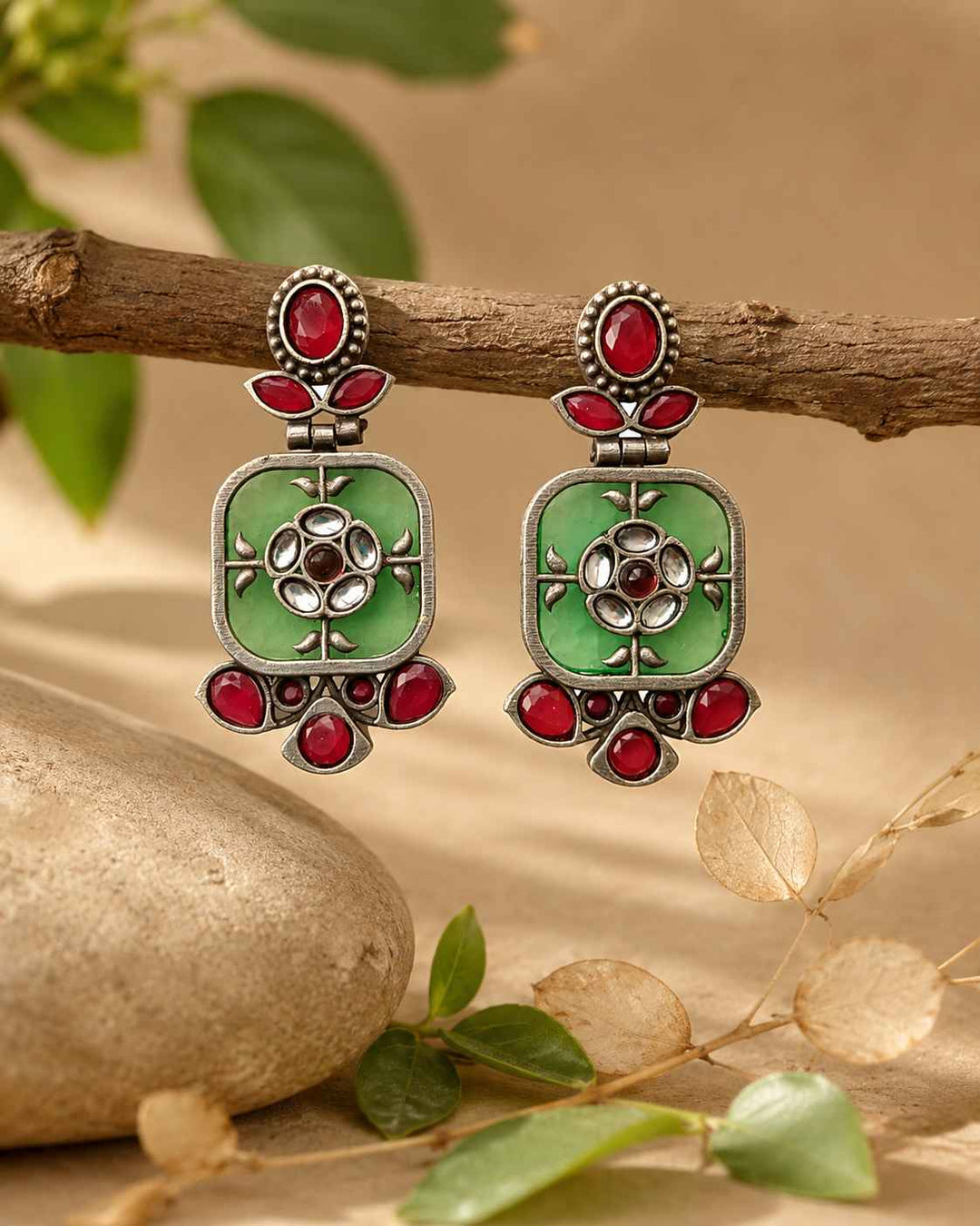 Push-back closure secures this silver-plated green dangler earring.
