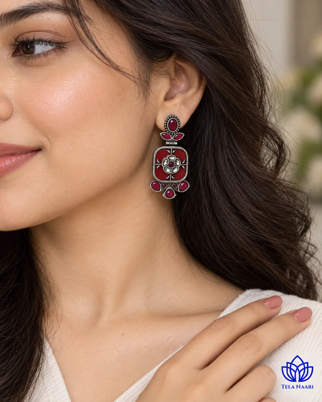 Bright red tones brighten the silhouette of this dangler earring.