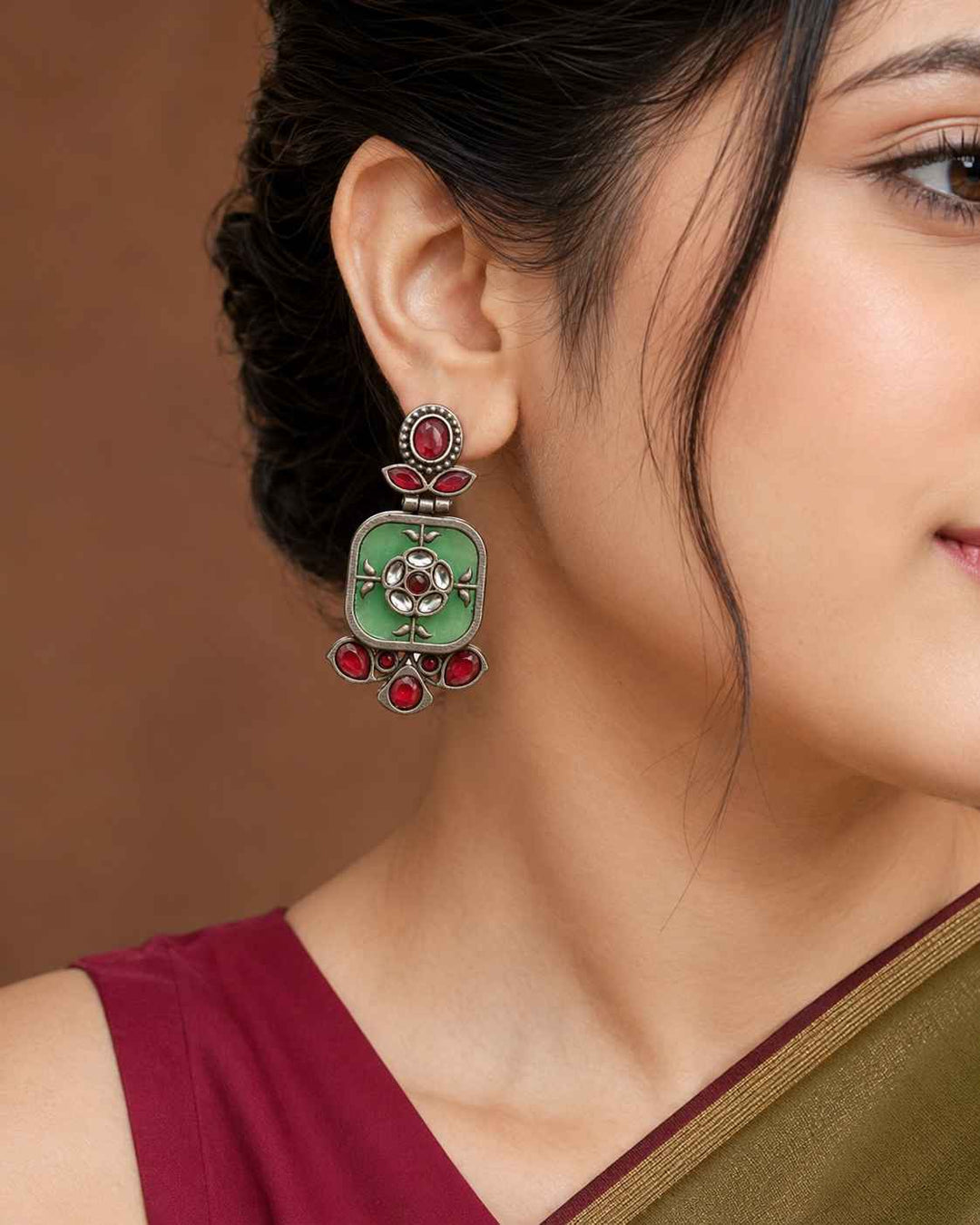 Cool green tone brightens the silver-plated surface of this earring.
