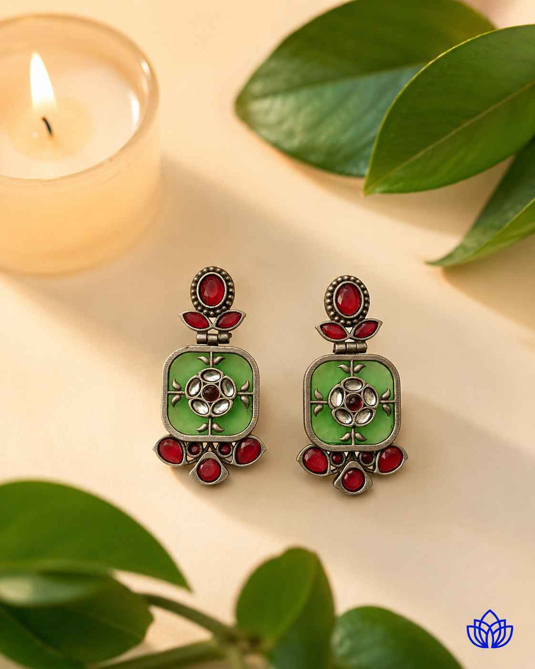 Polished silver-plated surface gives this green earring its shine.