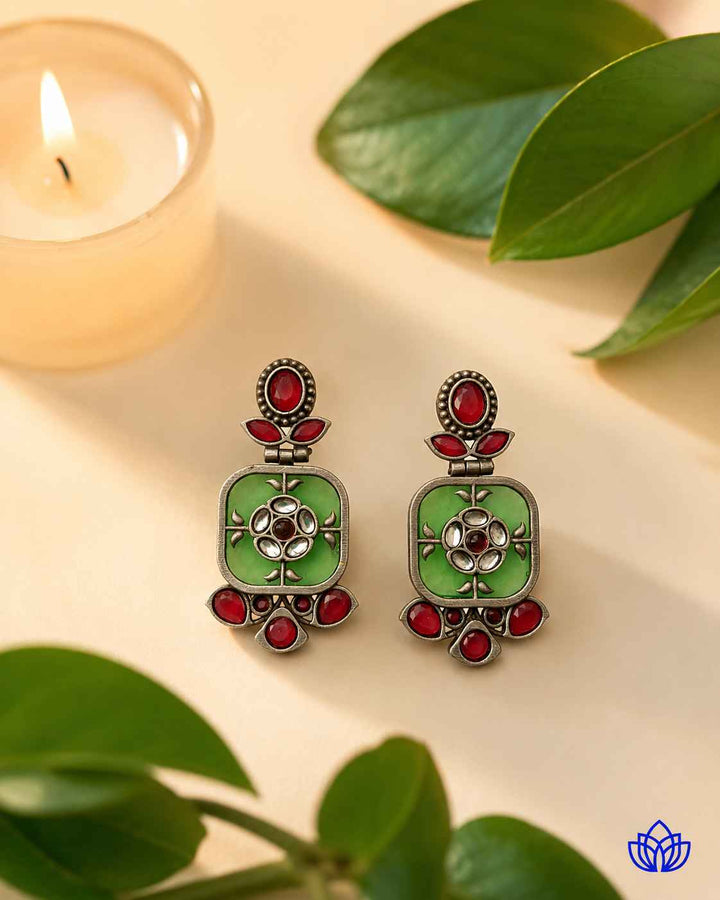 Polished silver-plated surface gives this green earring its shine.
