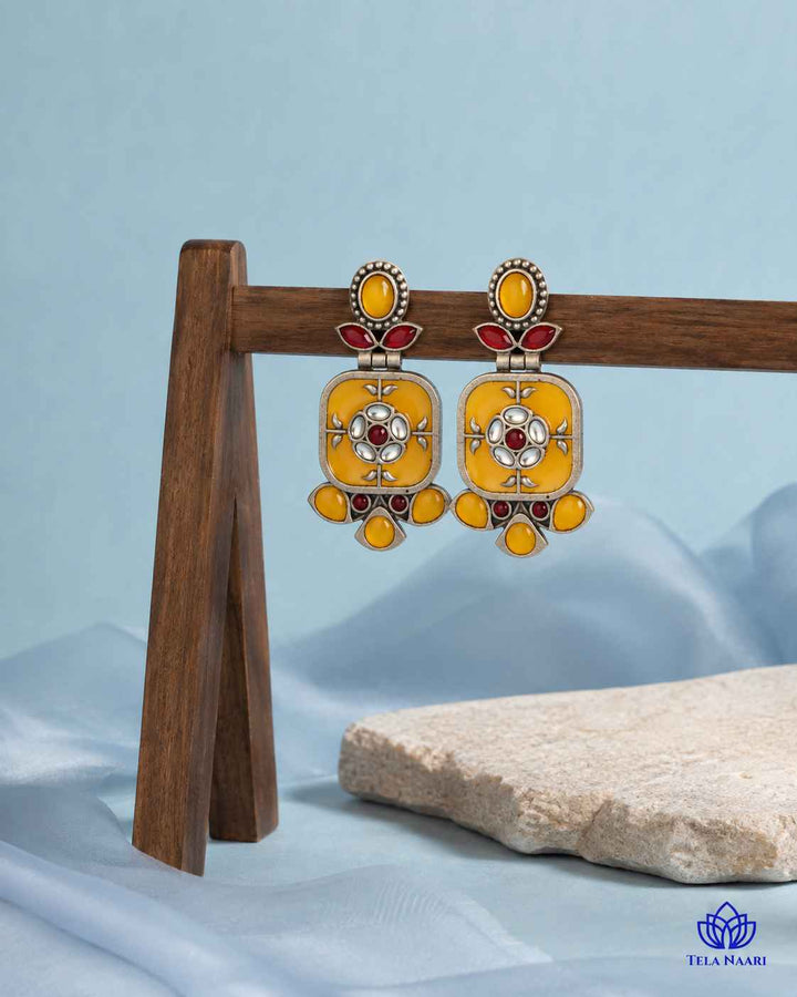Yellow tone brightens the silver-plated surface of this earring.